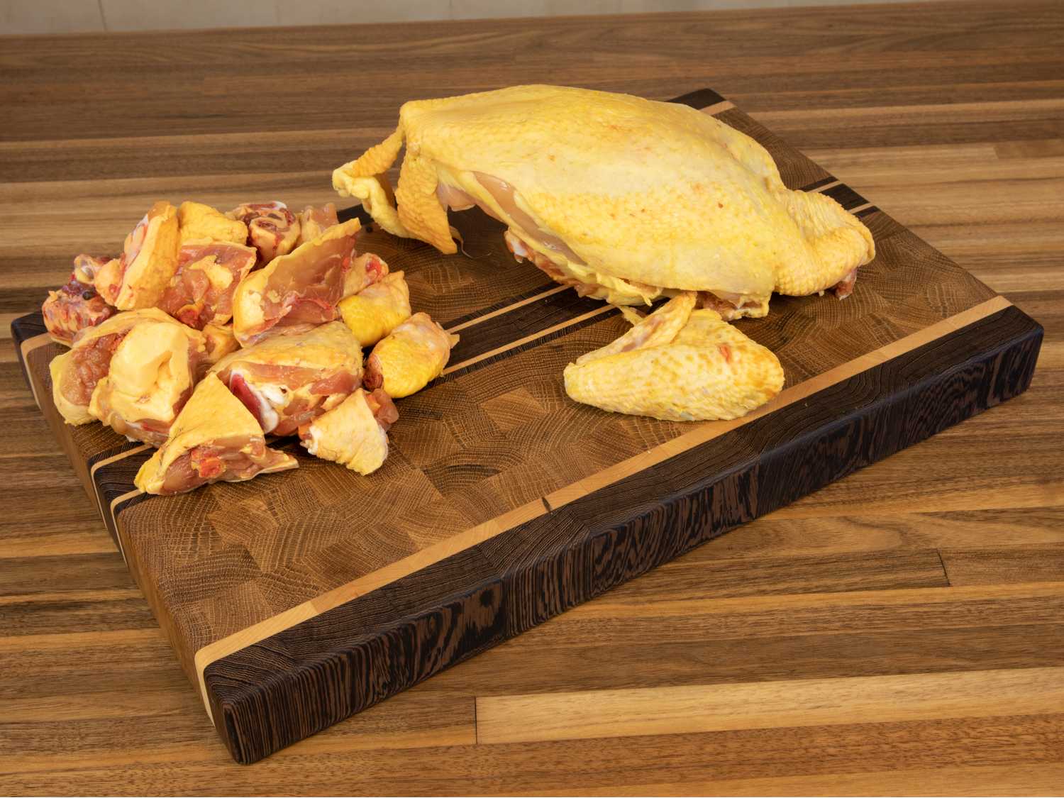 tabla de cocina de madera sobre la encimera cortando pollo
