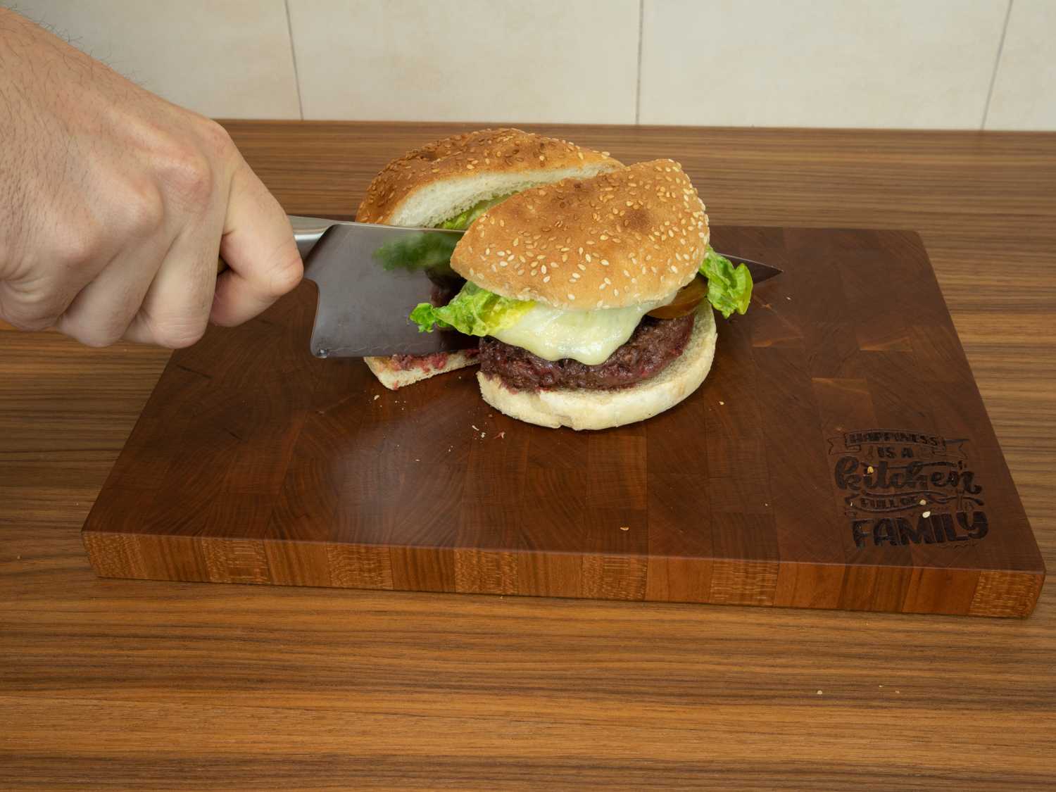 tabla de cocina de cerezo en la encimera cortando una hambuerguesa